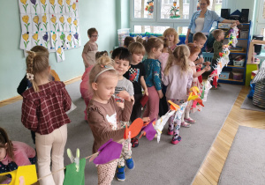 Dzieci wieszają pranie na sznurku, używając klamerek