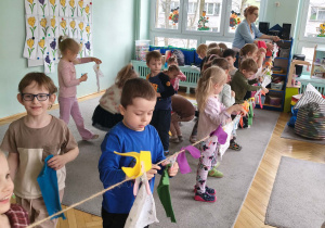 Dzieci wieszają pranie na sznurku, używając klamerek