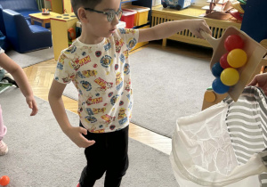 Dzieci sprzątają szufelkami kurz,którym były kolorowe kulki