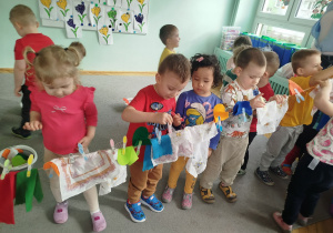 Dzieci wieszają pranie na sznurku, używając klamerek