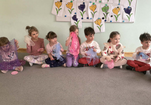 Dzieci przy muzyce zmywają naczynia kolorowymi chustami.