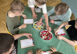 dzieci ozdabiają guzikami ramki na zdjęcia