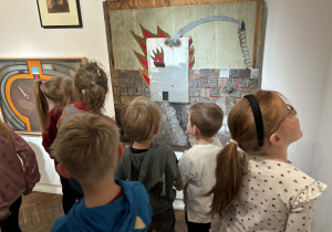 dzieci oglądają wystawę z obrazami i eksponatami i wypowiadają się na ich temat,