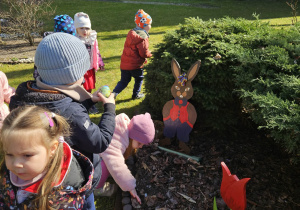 Dzieci szukają w ogrodzie ukrytych jajek