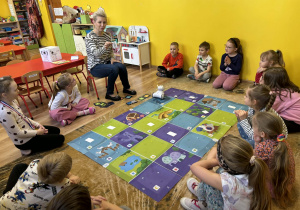 dzieci programują robota Franka i wykonują na macie do kodowania zadania,
