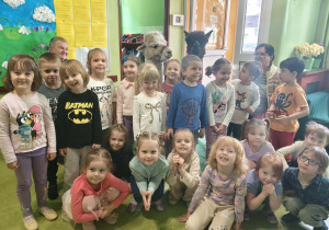 dzieci pozują do zdjęcia z alpakami