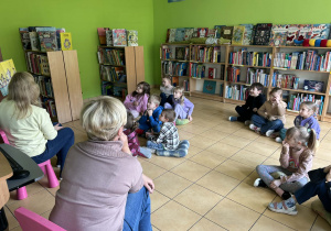 dzieci słuchają książki o pingwinach,