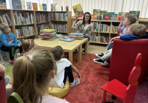 dzieci słuchają w bibliotece ciekawostek na temat różnych zakątków świata