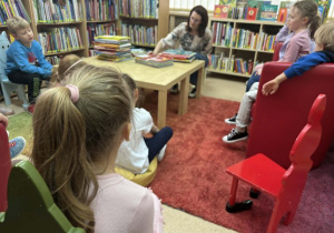 dzieci słuchają w bibliotece ciekawostek na temat różnych zakątków świata
