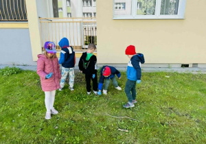 dzieci zbierają śmieci w okolicy przedszkola