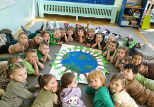 dzieci pozują do grupowego zdjęcia z wykonaną przez siebie pracą