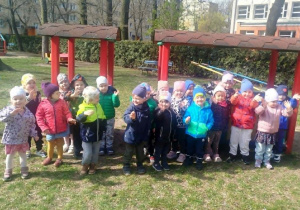 Dzieci pozują do zdjęcia grupowego przy ogrodowym pociągu