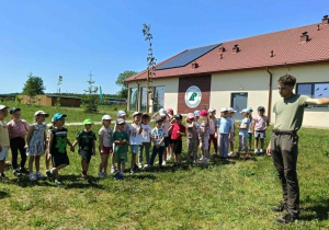 dzieci słuchają leśnika, który opowiada o zwierzętach