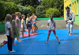 dzieci uczestniczą w pokazowych zajęciach judo