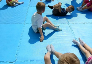 dzieci uczestniczą w pokazowych zajęciach judo