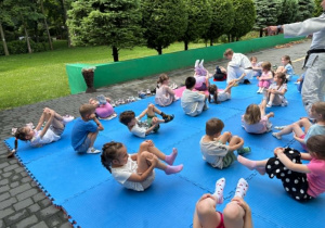 dzieci uczestniczą w pokazowych zajęciach judo
