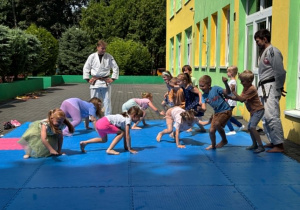dzieci uczestniczą w pokazowych zajęciach judo