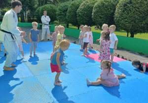 dzieci uczestniczą w pokazowych zajęciach judo
