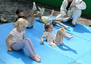 dzieci uczestniczą w pokazowych zajęciach judo