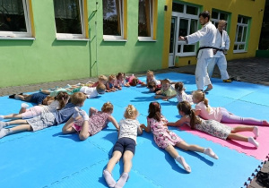 dzieci uczestniczą w pokazowych zajęciach judo