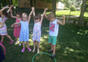 Dzieci przekładają hula-hoop bez użycia rąk