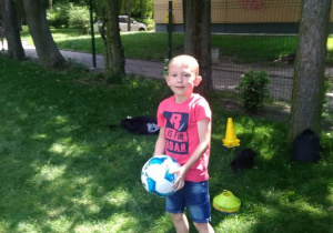 Chłopiec trzyma piłkę w rękach