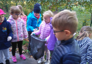 Dzieci zbierają śmieci na osiedlu