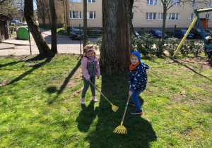 Chłopiec i dziewczynka grabią trawnik