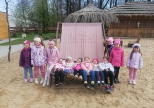 Grupa dziewczynek leży na dużym leżaku, 6 dziewczynek stoi obok leżaka