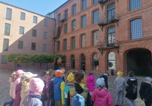 Dzieci obserwują budynek, przewodnik opisuje jego wygląd
