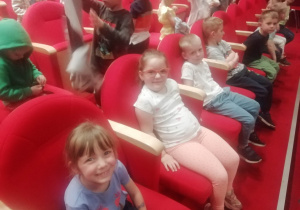 Dzieci siedzą na widowni w teatrze