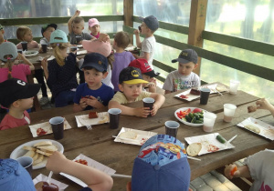 Dzieci spożywają posiłek w altanie