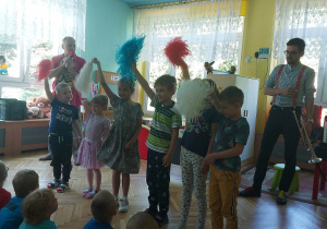 Sześcioro dzieci trzyma pompony i tańczy w rytm muzyki