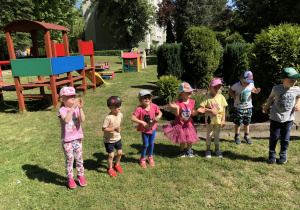 dzieci z grupy pomarańczowej biorą udział w zabawach tanecznych w ogrodzie