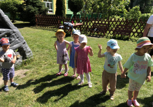 dzieci z grupy czerwonej biorą udział w zabawach ruchowych w ogrodzie