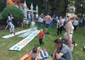 dzieci wraz z rodzicami grają w rozmaite gry w ogrodzie przedszkolnym