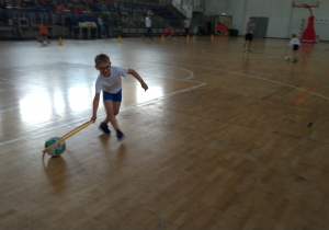 Chłopiec prowadzi piłkę przy pomocy hula-hop