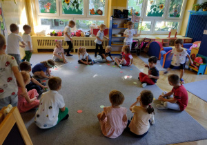 Dzieci uczestniczą w zabawie ruchowej z wykorzystaniem kolorowych kropek