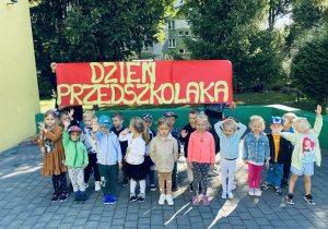 Grupa czerwona pozuje do zdjęcia grupowego na tarasie przedszkolnym