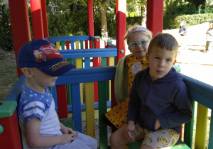 Dzieci siedzą w drewnianej kolejce