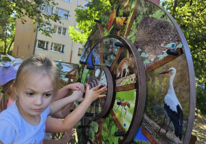 dziewczynka rozwiązuje zadanie na zegarze.