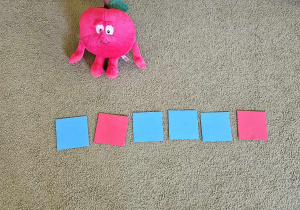 Dzieci układają model słowa z kartoników niebieskich i czerwonych.
