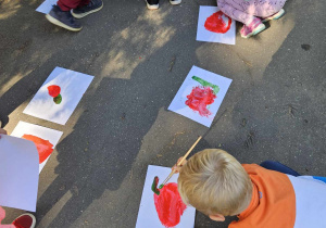 dzieci malują farbami na chodniku