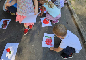 dzieci malują farbami na chodniku