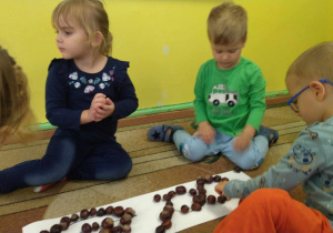 Dzieci układają wzory/kształty wykorzystując kasztany