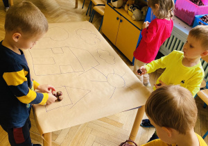 Dzieci układają wzory/kształty wykorzystując kasztany