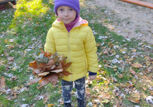 dziewczynka trzyma bukiet z liści