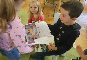 Chłopiec sprawdzą prace w książce dziewczynki.