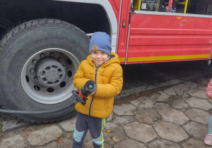 Chętne dzieci trzymają wąż strażacki