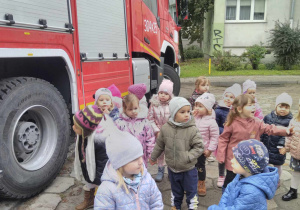 Dzieci z grupy żółtej stoją przy wozie strażackim